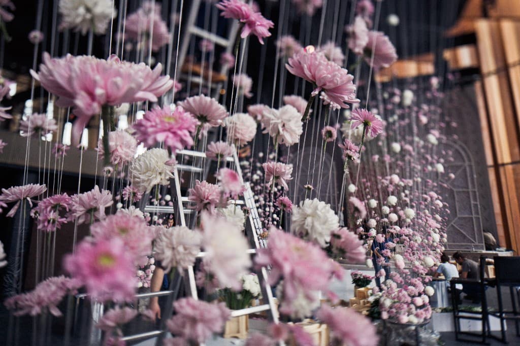 Pink and white floral installation suspended from the ceiling at a corporate event